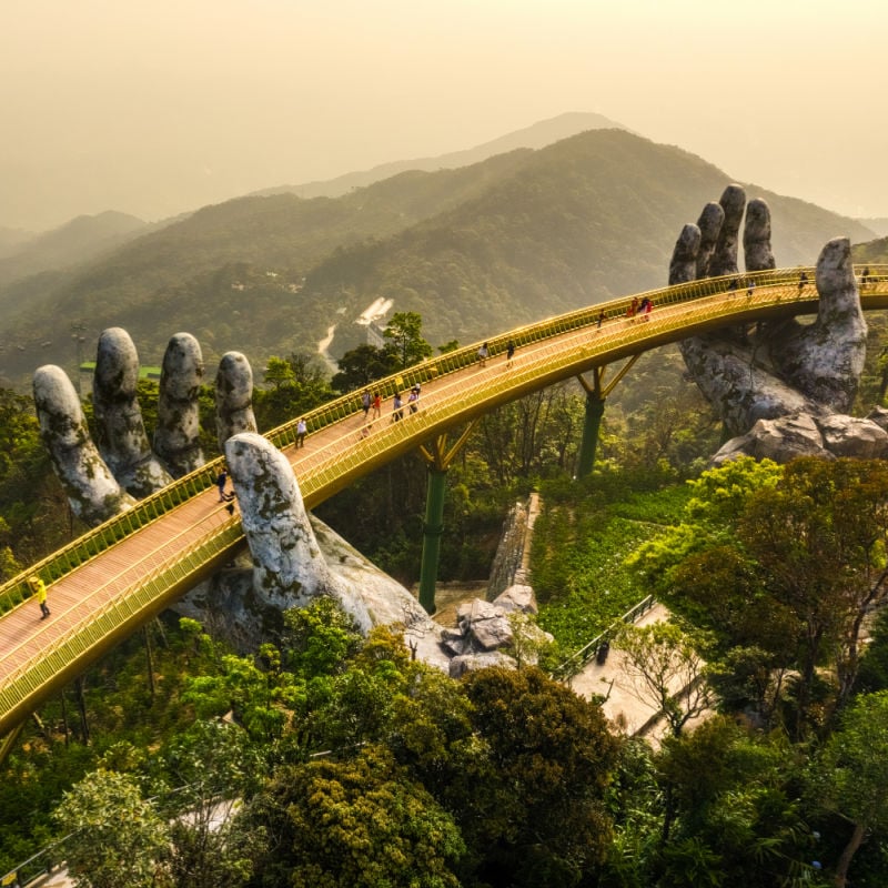 aerial-view-of-the-famous-Golden-Bridge-is-lifted-by-two-giant-hands-in-the-tourist-resort-on-Ba-Na-Hill-in-Da-Nang-Vietnam